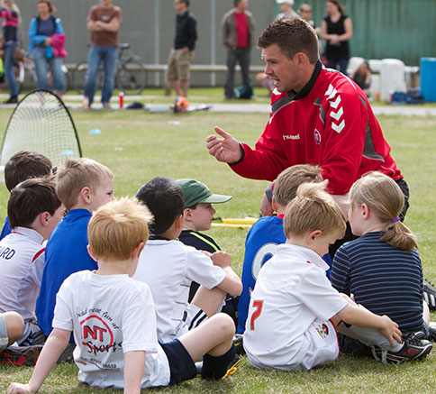 Coach briefing a group of young footballers
